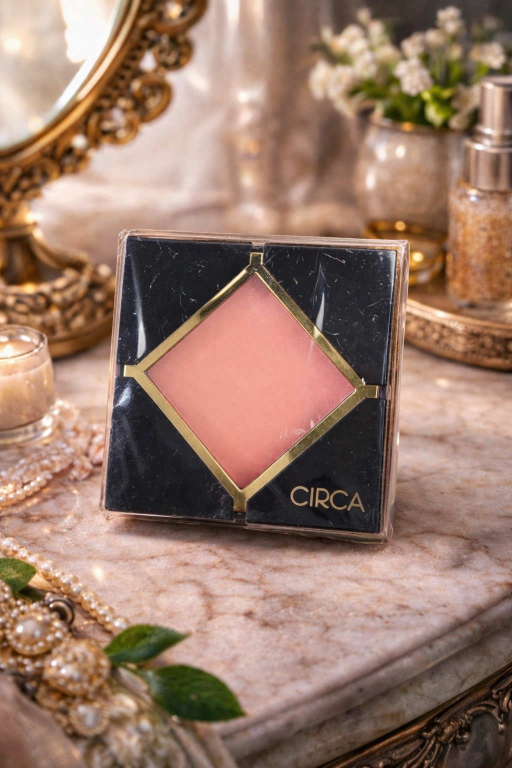 Circa blush compact on a decorative table with a mirror and flowers in the background