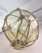 Vintage Light Amber Glass Fishing Float with Rope Netting – 7" Maritime Buoy with Internal Sea Mist Patina Hand Blown